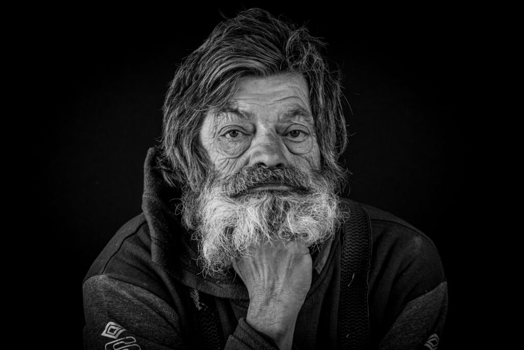 Pre čiernobiely portrét sa zameraj na svetlo, kontrast a emócie, buď nastav fotoaparát rovno na monochromatický režim (napr. s farebnými filtrami pre dramatickejší efekt), alebo farebný záber upravuj v editore. Kľúčové je hľadať silné línie, textúry a výrazy tváre, ideálne využiť prirodzené svetlo (okno) pre rovnomerné osvetlenie a zapojiť okolie pre rozprávanie príbehu.